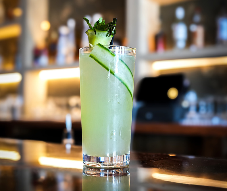 Handcrafted cucumber cocktail garnished with mint and cucumber ribbon at Coca Lounge in Levittown NY